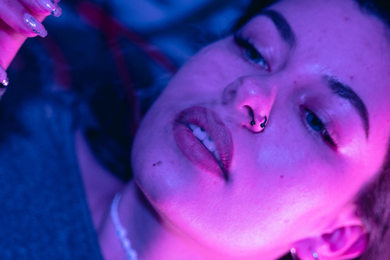 A close-up portrait of a woman illuminated by vibrant neon purple lighting, showcasing mood and style.